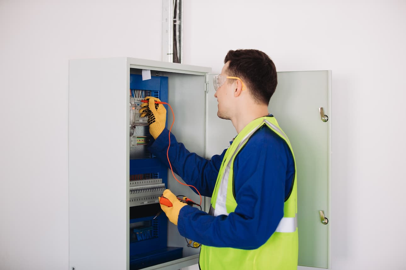 Electrician using a clamp meter to test a consumer unit